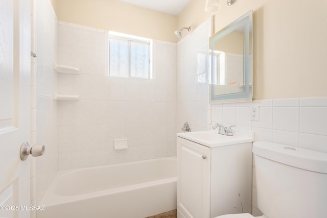 full bathroom featuring toilet, shower / washtub combination, tile walls, and vanity