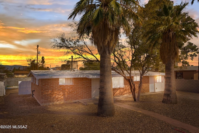 exterior space with brick siding and fence