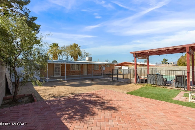 exterior space with a patio area, fence, and brick siding