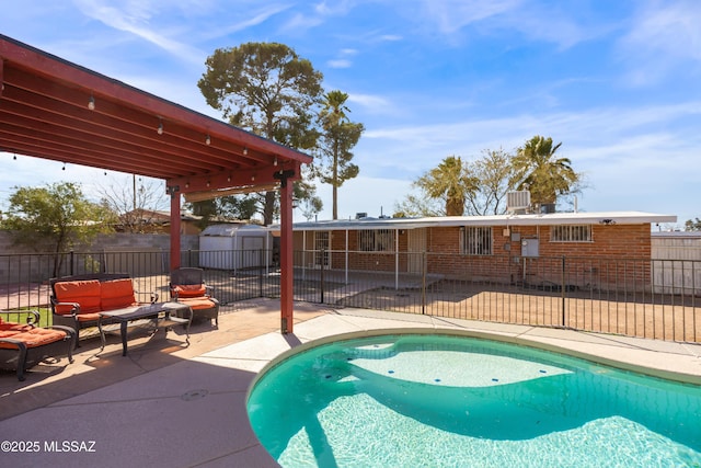 view of swimming pool featuring a patio, a fenced backyard, an outdoor structure, an outdoor living space, and a storage unit