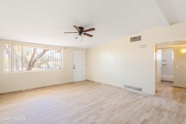 spare room with light wood finished floors, visible vents, and a ceiling fan