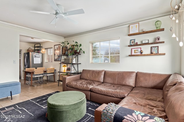 living area featuring ceiling fan and ornamental molding