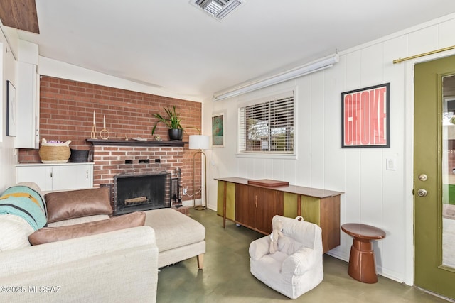 living room featuring a fireplace, visible vents, and finished concrete floors