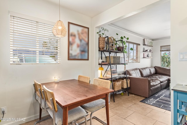 dining area with light tile patterned floors and ornamental molding