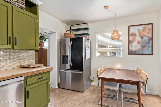 kitchen with light tile patterned floors, baseboards, green cabinetry, appliances with stainless steel finishes, and tasteful backsplash