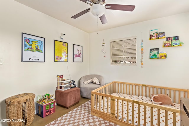 bedroom with a crib and ceiling fan