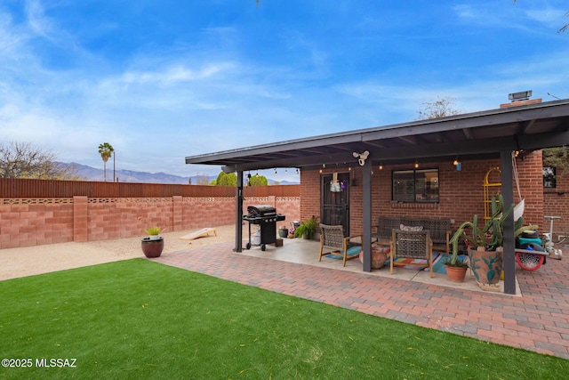 view of patio featuring grilling area, a mountain view, and fence