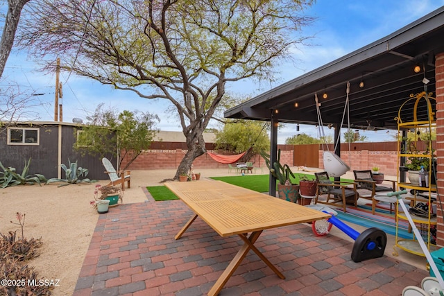 view of patio / terrace featuring an outbuilding and fence