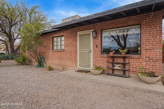 property entrance featuring brick siding