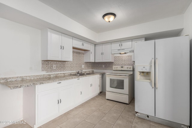 kitchen featuring white appliances, under cabinet range hood, light countertops, and a sink