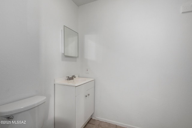 half bathroom with tile patterned flooring, vanity, and toilet