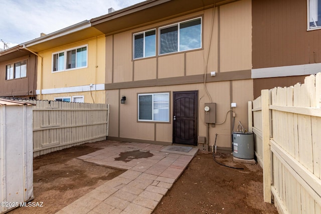 back of house with a patio area, fence, and gas water heater