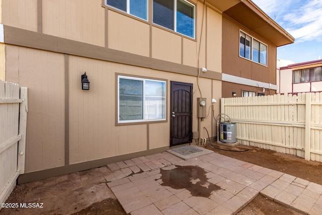 exterior space with water heater, a patio area, and fence