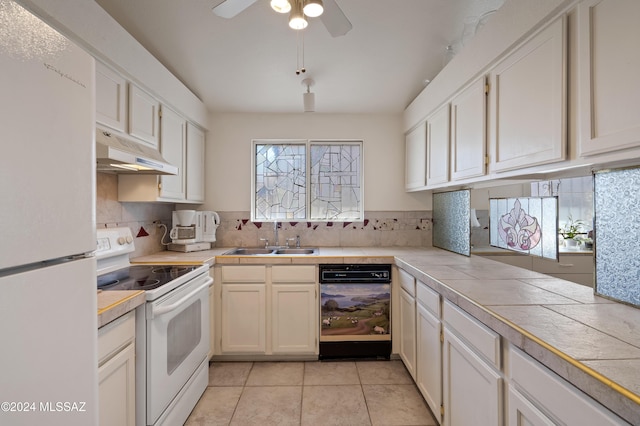 kitchen featuring tile countertops, white appliances, under cabinet range hood, and a sink