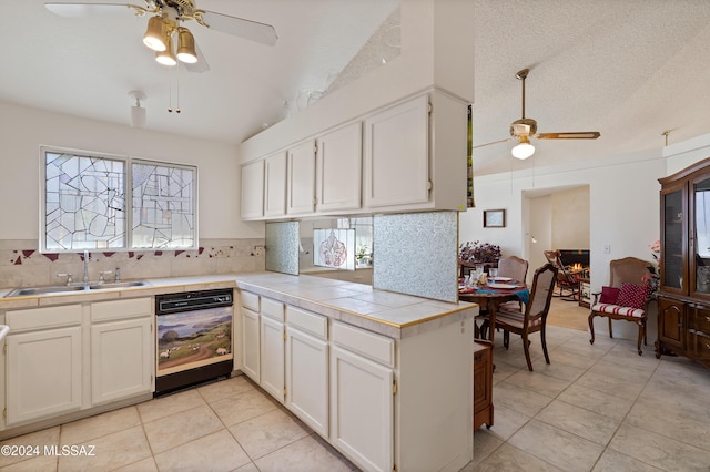 kitchen featuring decorative backsplash, white cabinets, a sink, and dishwashing machine