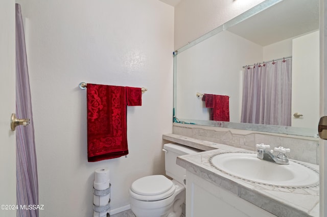 full bathroom with curtained shower, vanity, and toilet