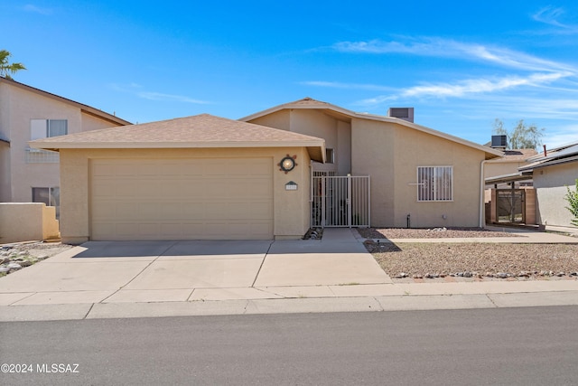 view of front facade featuring a garage, a gate, concrete driveway, and stucco siding