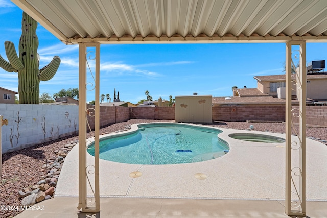 view of pool with an in ground hot tub, a patio, a fenced backyard, and a fenced in pool