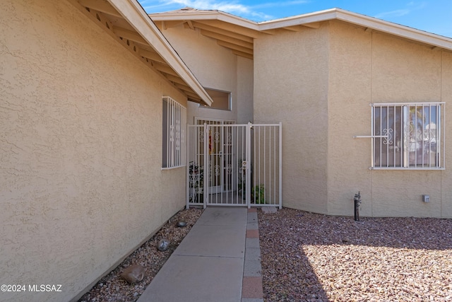 view of side of property with a gate and stucco siding