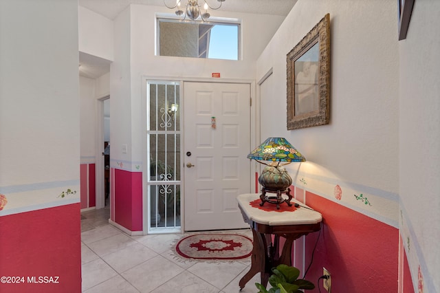 tiled foyer featuring an inviting chandelier