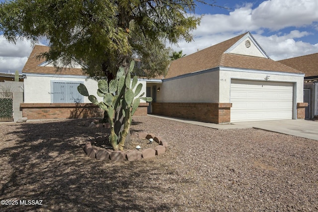 view of front of house featuring brick siding, stucco siding, a shingled roof, concrete driveway, and a garage