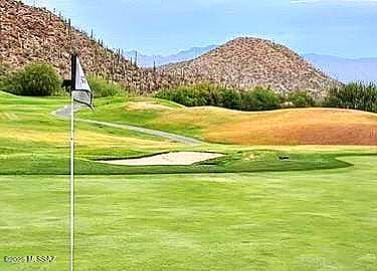 surrounding community with a mountain view and view of golf course