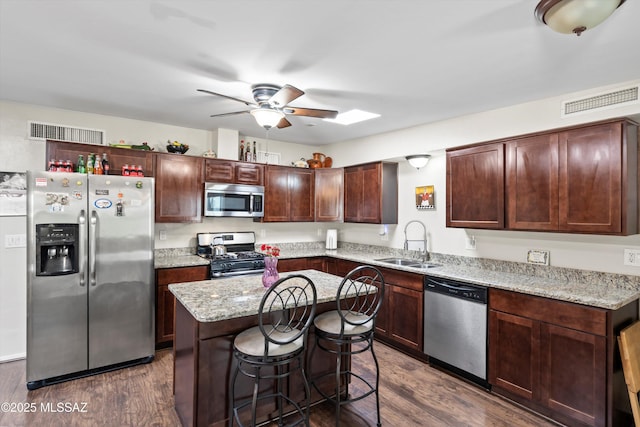 kitchen featuring visible vents, dark wood-style flooring, ceiling fan, a sink, and appliances with stainless steel finishes