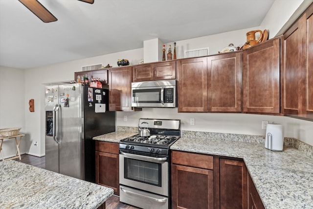 kitchen featuring light stone counters, appliances with stainless steel finishes, ceiling fan, and dark wood-style flooring