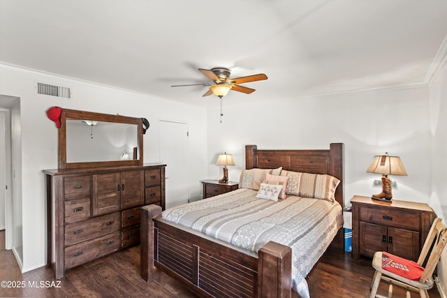 bedroom with crown molding, dark wood-style floors, visible vents, and ceiling fan