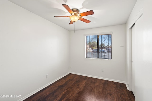 unfurnished bedroom with a closet, baseboards, ceiling fan, and dark wood-style flooring