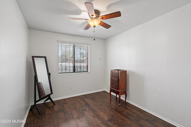 unfurnished room featuring baseboards, ceiling fan, and dark wood-style flooring