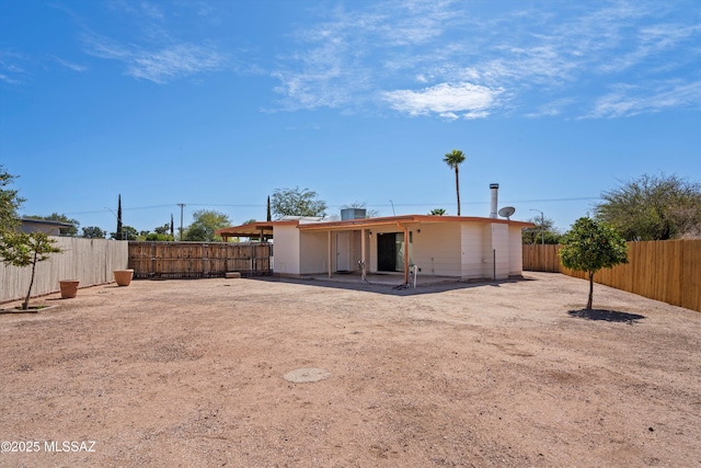 rear view of house with a fenced backyard and a patio area