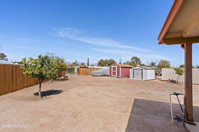 view of yard with an outbuilding, a storage shed, and a fenced backyard