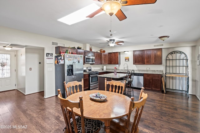 dining area with dark wood finished floors, visible vents, baseboards, and a ceiling fan