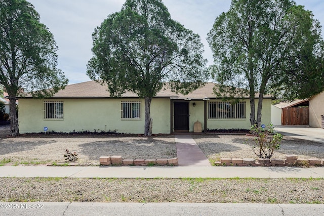 ranch-style house with fence and stucco siding