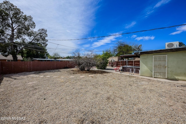 view of yard with central AC and fence