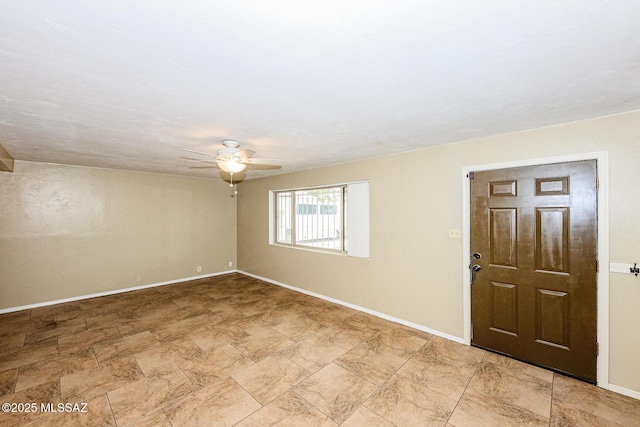 empty room featuring baseboards and a ceiling fan