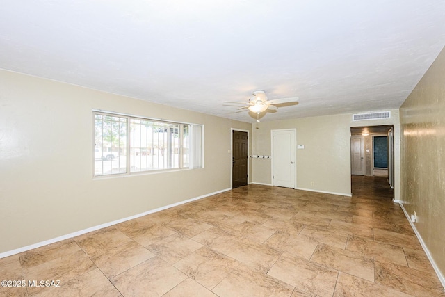 unfurnished room featuring baseboards, visible vents, and a ceiling fan