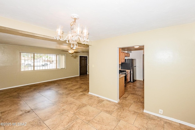 empty room featuring baseboards and an inviting chandelier