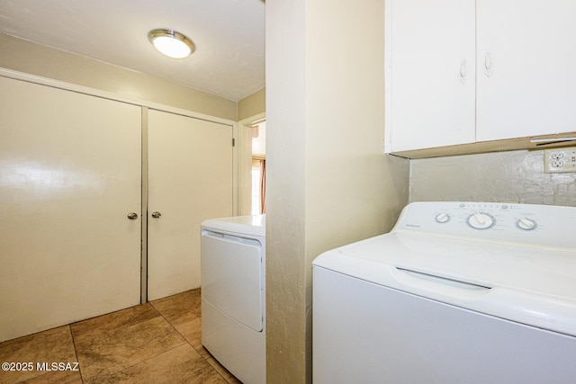 washroom featuring cabinet space, washer and clothes dryer, and light tile patterned flooring