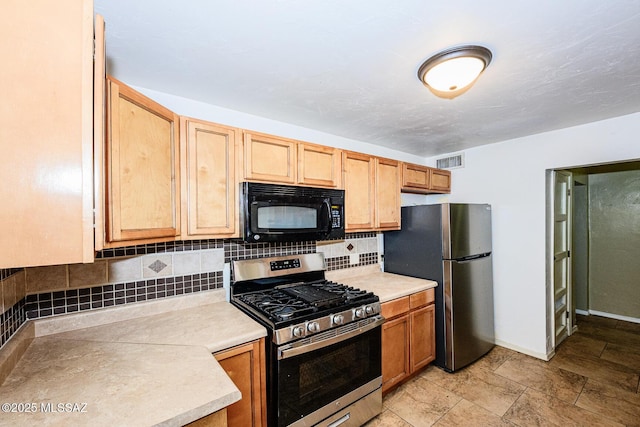 kitchen with baseboards, visible vents, appliances with stainless steel finishes, light countertops, and backsplash