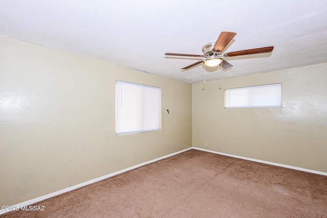 carpeted spare room featuring baseboards