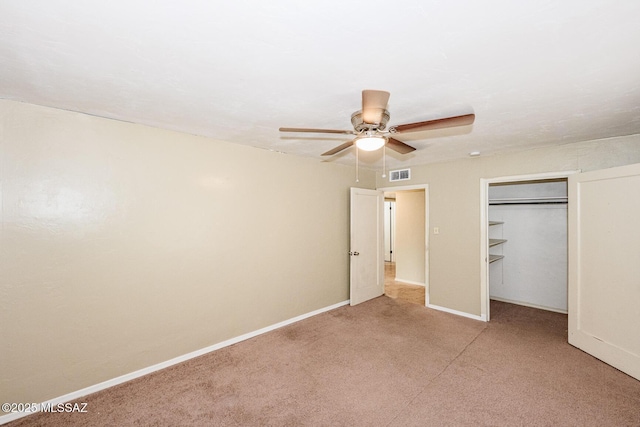 unfurnished bedroom with baseboards, visible vents, light colored carpet, ceiling fan, and a closet