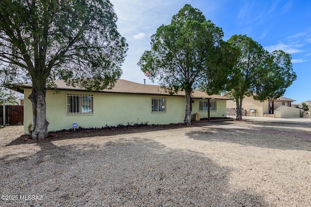 view of front facade featuring fence and stucco siding