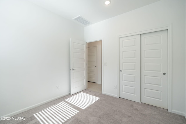 unfurnished bedroom with a closet, carpet flooring, visible vents, and baseboards