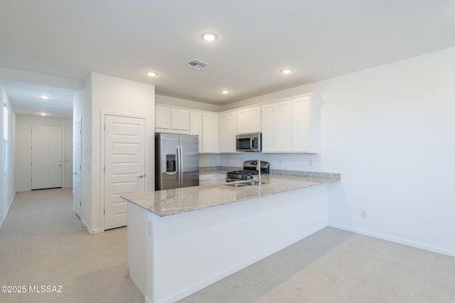 kitchen with light stone counters, stainless steel appliances, a peninsula, visible vents, and white cabinetry