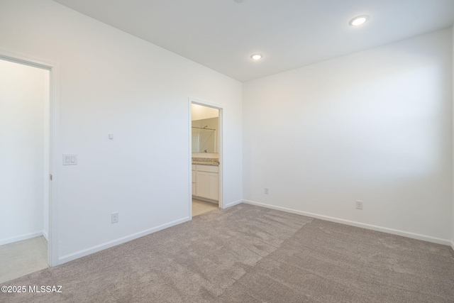 spare room featuring light carpet, baseboards, and recessed lighting