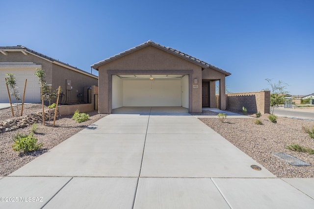 ranch-style home featuring stucco siding, an attached garage, fence, driveway, and a tiled roof