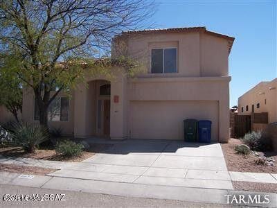 view of front of house featuring driveway, an attached garage, and stucco siding