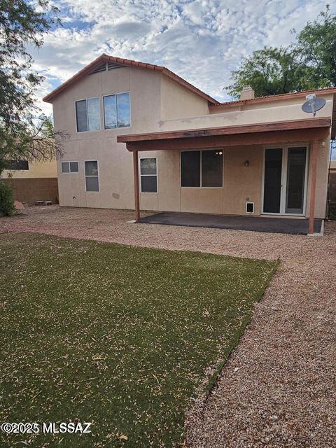 back of property featuring a yard, a patio, and stucco siding